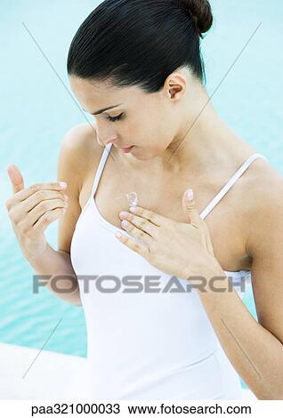 Woman applying sunscreen to chest View Large Photo Image Stock Image - Woman applying sunscreen to chest. Fotosearch