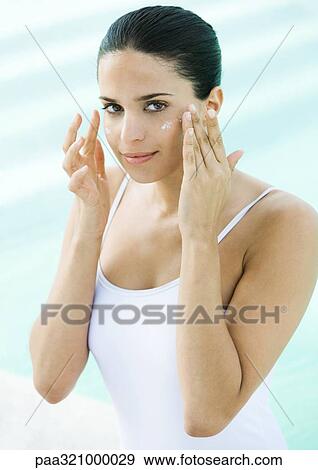 Woman applying sunscreen to face View Large Photo Image Stock Photo - Woman applying sunscreen to face. Fotosearch