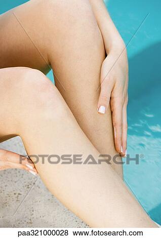 Stock Photo - Woman rubbing legs. Fotosearch