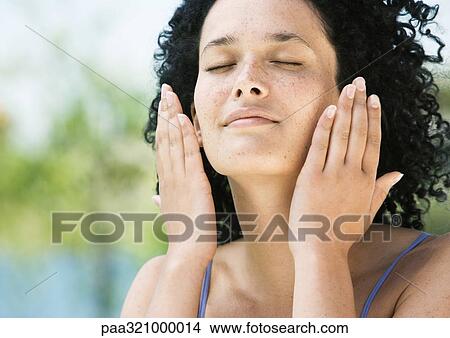 Young woman with eyes closed and hands near face View Large Photo Image Picture - Young woman with eyes closed and hands near face. Fotosearch