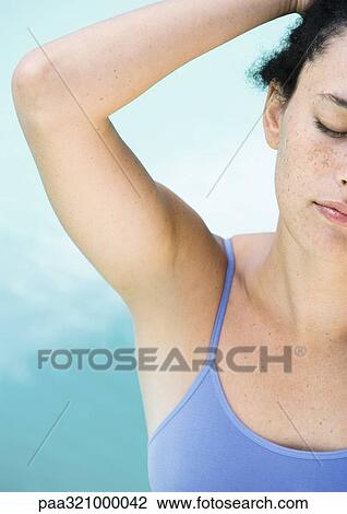Young woman with hand behind head, partial view View Large Photo Image Stock Image - Young woman with hand behind head, partial view. Fotosearch