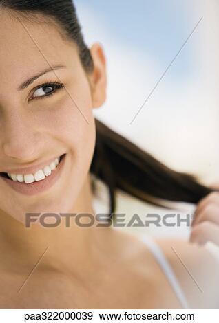 Woman smiling and touching hair View Large Photo Image Stock Photo - Woman smiling and touching hair. Fotosearch