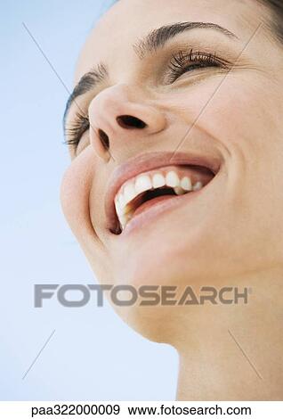 Woman smiling, low angle view View Large Photo Image Stock Photo - Woman smiling, low angle view. Fotosearch