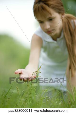 Stock Image - Girl looking at plant. Fotosearch