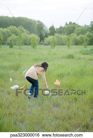 Woman picking up plastic bags in field View Large Photo Image Stock Photograph - Woman picking up plastic bags in field. Fotosearch