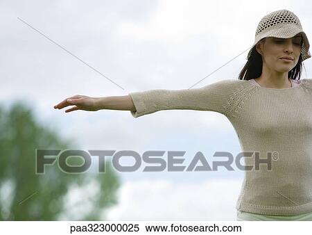 Woman standing outdoors with arms out, cropped View Large Photo Image Stock Photography - Woman standing outdoors with arms out, cropped. Fotosearch