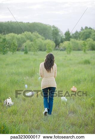 Woman walking in field strewn with plastic bags View Large Photo Image Stock Photo - Woman walking in field strewn with plastic bags. Fotosearch