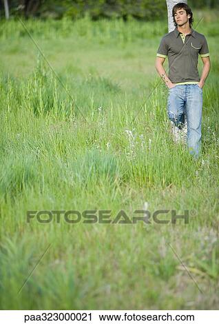 Young man leaning against tree with eyes closed View Large Photo Image Stock Image - Young man leaning against tree with eyes closed. Fotosearch