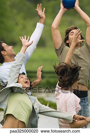 Group of young adult friends playing with ball View Large Photo Image Stock Image - Group of young adult friends playing with ball. Fotosearch