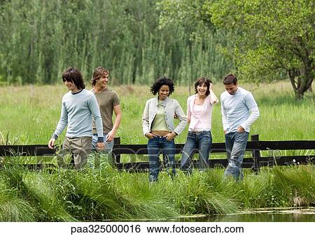 Group of young friends walking outdoors View Large Photo Image Stock Photograph - Group of young friends walking outdoors. Fotosearch