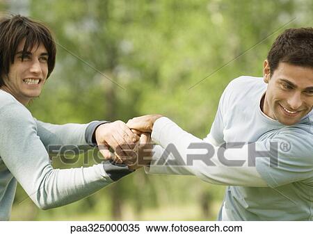 Two male friends clasping hands playfully View Large Photo Image Stock Photography - Two male friends clasping hands playfully. Fotosearch
