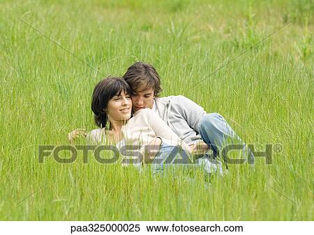 Young couple lying in grass together View Large Photo Image Stock Photography - Young couple lying in grass together. Fotosearch