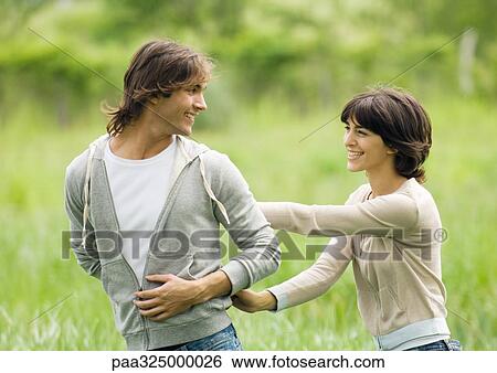 Young couple outdoors, man looking at woman over shoulder View Large Photo Image Stock Photograph - Young couple outdoors, man looking at woman over shoulder. Fotosearch