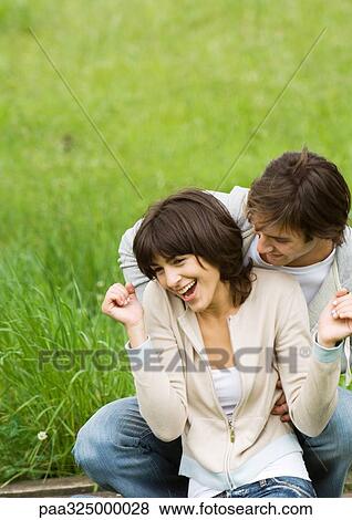 Young couple outdoors, man tickling woman View Large Photo Image Stock Photo - Young couple outdoors, man tickling woman. Fotosearch
