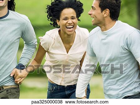 Stock Photo - Young friends running and laughing. Fotosearch