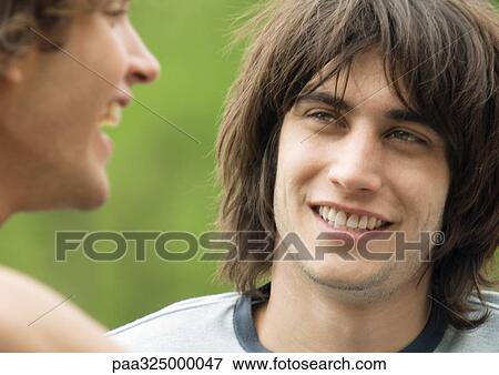Young man listening to friend View Large Photo Image Stock Photo - Young man listening to friend. Fotosearch