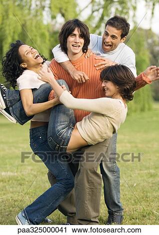 Young people jumping on friend playfully View Large Photo Image Stock Image - Young people jumping on friend playfully. Fotosearch