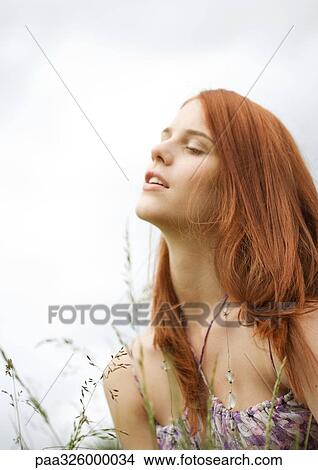 Redheaded young woman in grass View Large Photo Image Picture - Redheaded young woman in grass. Fotosearch