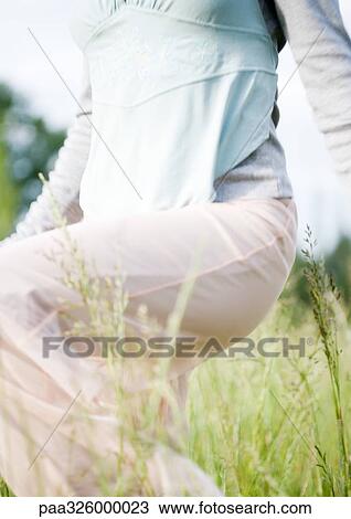 Woman walking through grass, view from chest down View Large Photo Image Stock Image - Woman walking through grass, view from chest down. Fotosearch