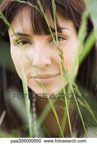 Woman's face seen through blades of grass View Large Photo Image Stock Image - Woman's face seen through blades of grass. Fotosearch
