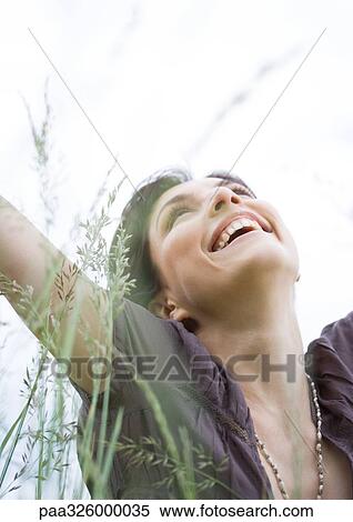 Young woman in grass, head back and smiling View Large Photo Image Stock Photography - Young woman in grass, head back and smiling. Fotosearch