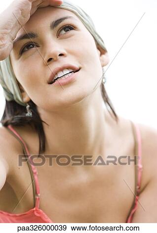 Young woman shading eyes and looking up, portrait View Large Photo Image Stock Photo - Young woman shading eyes and looking up, portrait. Fotosearch