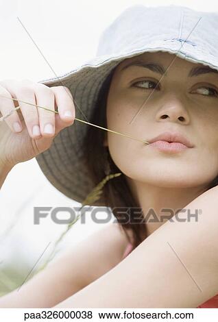 Young woman with blade of grass in mouth View Large Photo Image Stock Photo - Young woman with blade of grass in mouth. Fotosearch