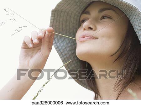Young woman with blade of grass in mouth View Large Photo Image Stock Photograph - Young woman with blade of grass in mouth. Fotosearch