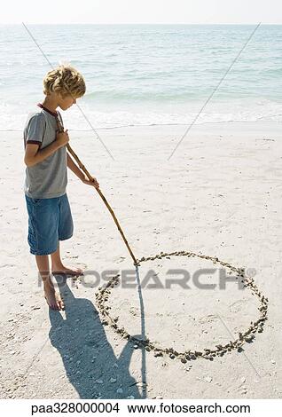 Boy drawing circle in sand View Large Photo Image Picture - Boy drawing circle in sand. Fotosearch