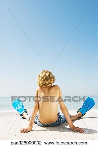 Boy wearing flippers sitting on beach, rear view View Large Photo Image Stock Image - Boy wearing flippers sitting on beach, rear view. Fotosearch
