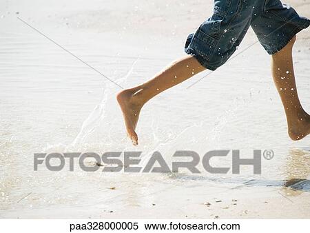 Stock Photography - Child running in surf at the beach. Fotosearch