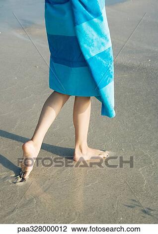 Child wrapped in towel walking on wet sand View Large Photo Image Stock Image - Child wrapped in towel walking on wet sand. Fotosearch