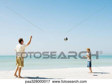 Father and son throwing ball on beach View Large Photo Image Stock Photo - Father and son throwing ball on beach. Fotosearch