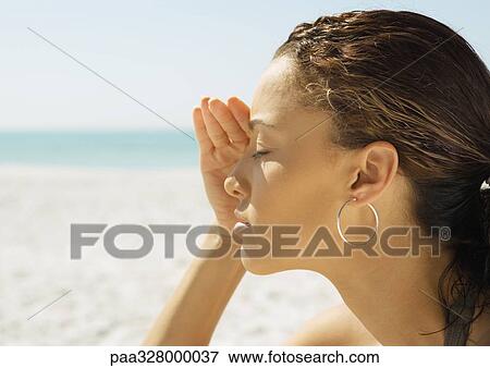Woman shading eyes on beach, close-up View Large Photo Image Stock Photo - Woman shading eyes on beach, close-up. Fotosearch