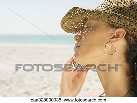 Woman using cell phone on beach, close-up View Large Photo Image Stock Photo - Woman using cell phone on beach, close-up. Fotosearch