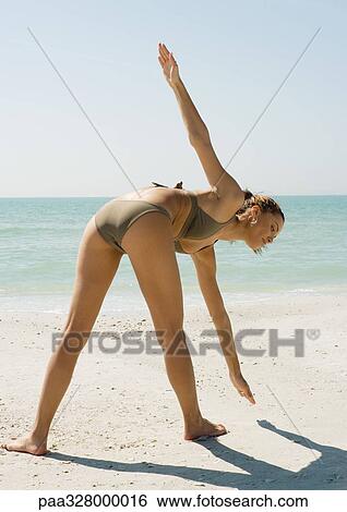 Young woman doing exercise on beach, rear view View Large Photo Image Stock Photograph - Young woman doing exercise on beach, rear view. Fotosearch