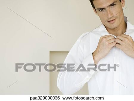 Man buttoning shirt View Large Photo Image Stock Photograph - Man buttoning shirt. Fotosearch