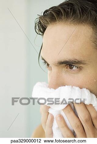Stock Image - Man drying face with towel. Fotosearch