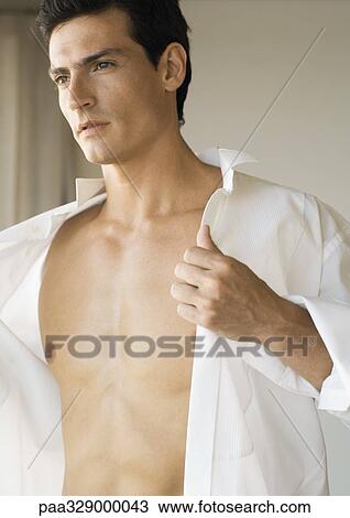 Man putting on shirt View Large Photo Image Stock Image - Man putting on shirt. Fotosearch