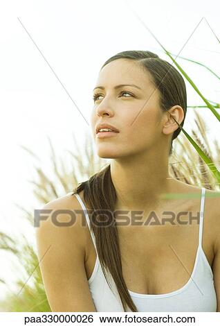 Stock Photograph - Woman in long grass, looking up. Fotosearch