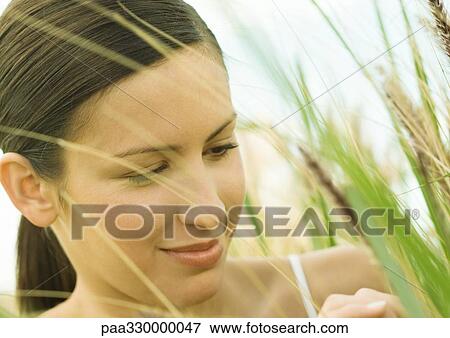 Woman in tall grass, close-up View Large Photo Image Stock Photo - Woman in tall grass, close-up. Fotosearch