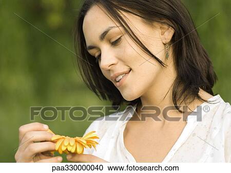 Stock Image - Woman plucking petals from flower. Fotosearch