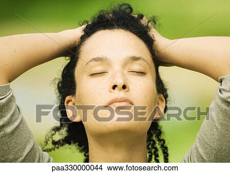 Woman with hands on head and eyes closed View Large Photo Image Picture - Woman with hands on head and eyes closed. Fotosearch