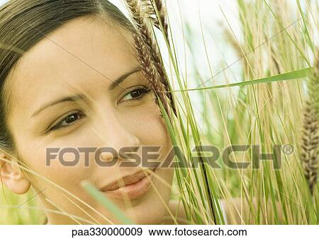 Stock Photo - Woman's face in long grass. Fotosearch