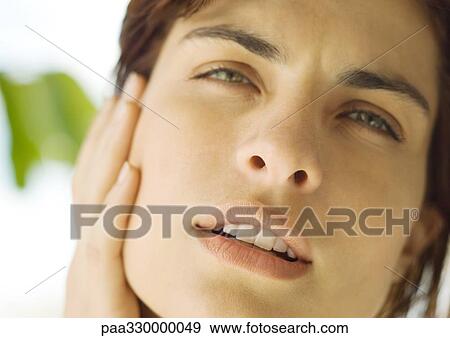 Stock Photo - Woman's face with hand on cheek. Fotosearch