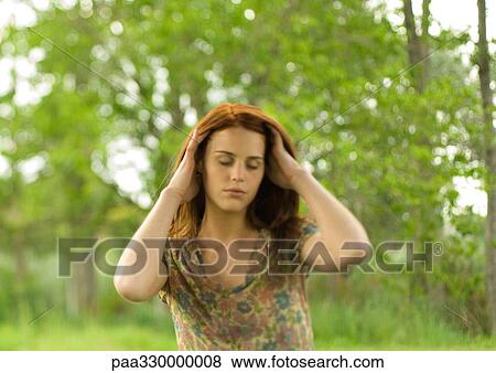 Young woman pushing hands through hair, eyes shut View Large Photo Image Stock Photo - Young woman pushing hands through hair, eyes shut. Fotosearch
