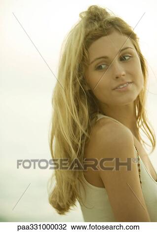 Woman looking over shoulder and smiling View Large Photo Image Stock Image - Woman looking over shoulder and smiling. Fotosearch