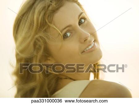 Stock Photograph - Woman looking over shoulder at camera. Fotosearch