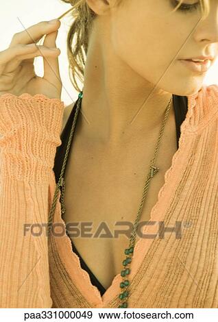 Stock Photo - Woman pulling strand of hair, close-up. Fotosearch