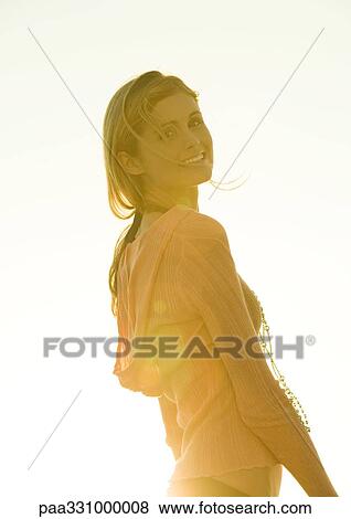 Woman standing in sun, looking over shoulder View Large Photo Image Stock Photo - Woman standing in sun, looking over shoulder. Fotosearch